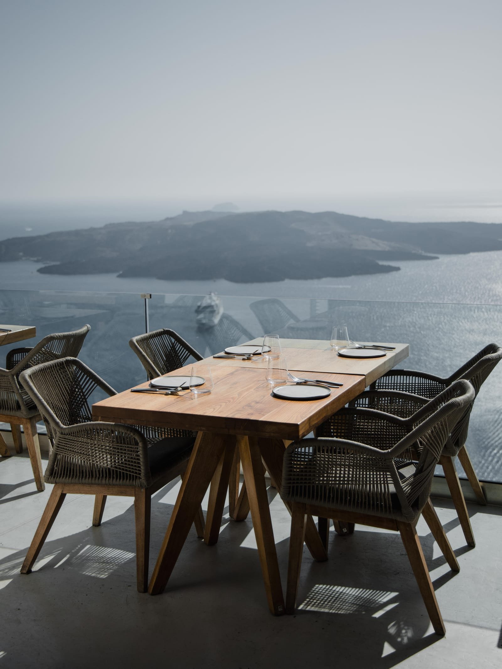 Kaliya Restaurant, Fira, Santorini — terrace table set for dinner with the volcano and caldera behind