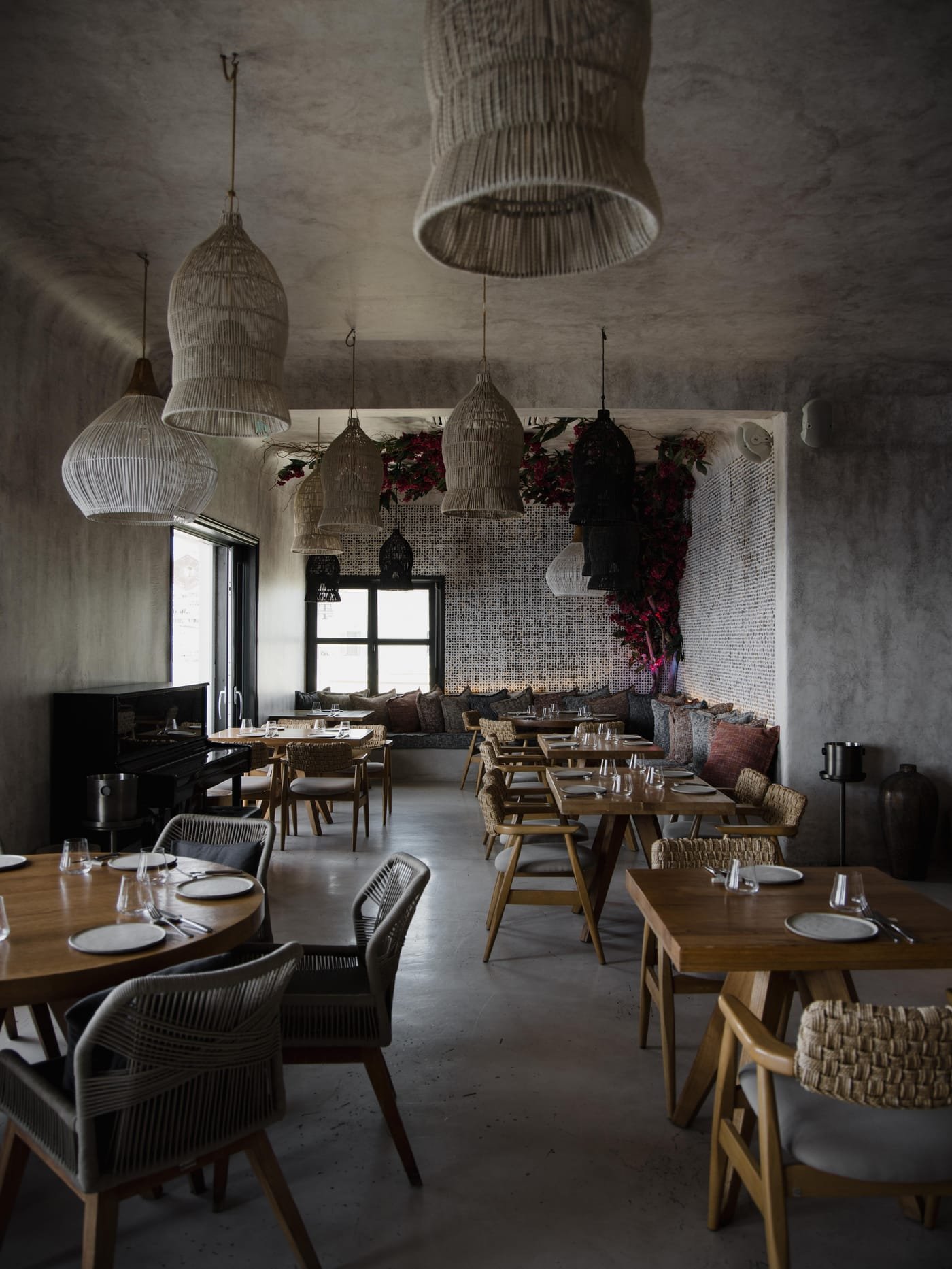 Kaliya Restaurant, Fira, Santorini — indoor dining room with wooden tables and woven chairs