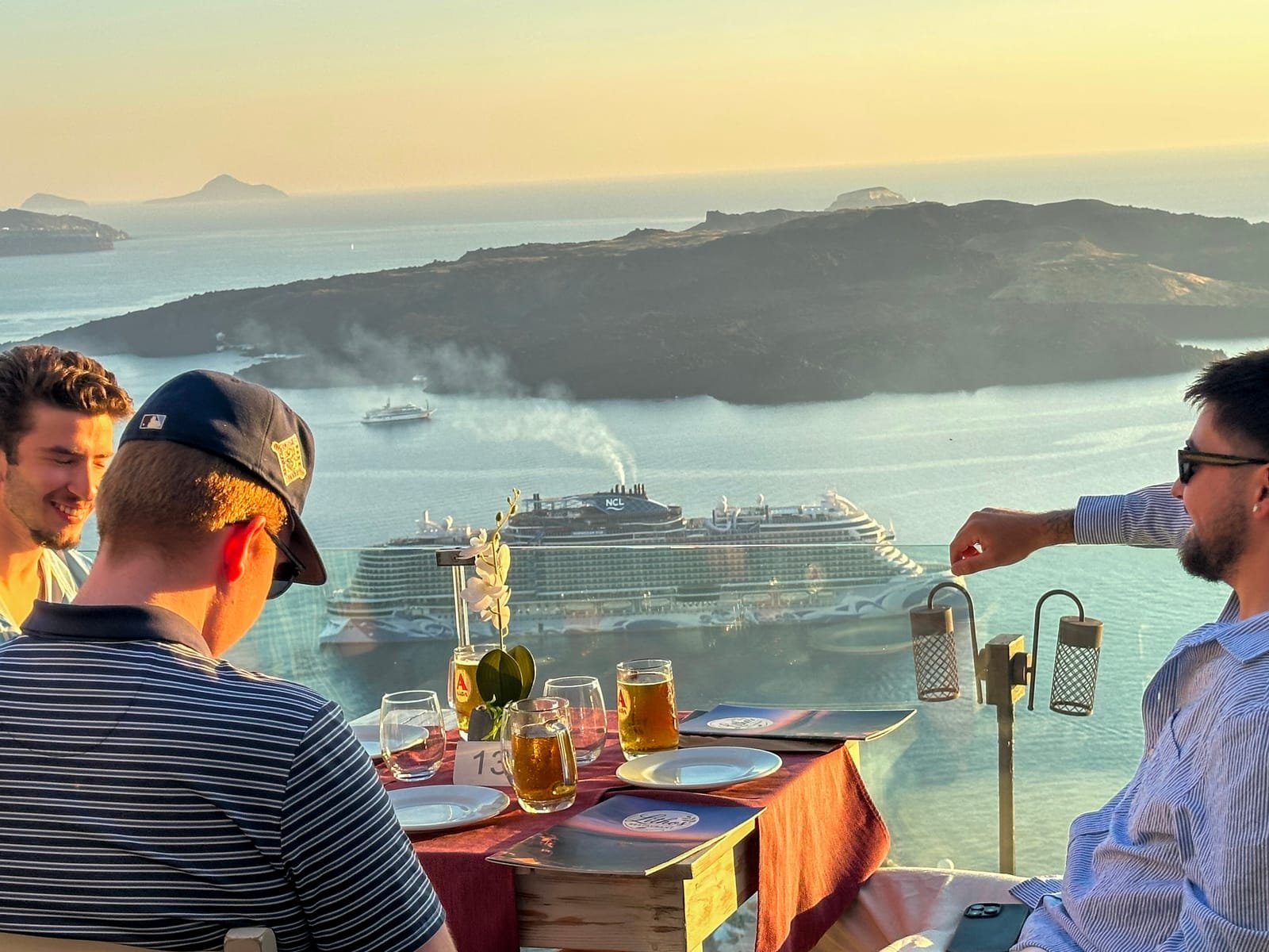 Lithos Restaurant, Fira, Santorini — friends at a table overlooking the volcano and caldera