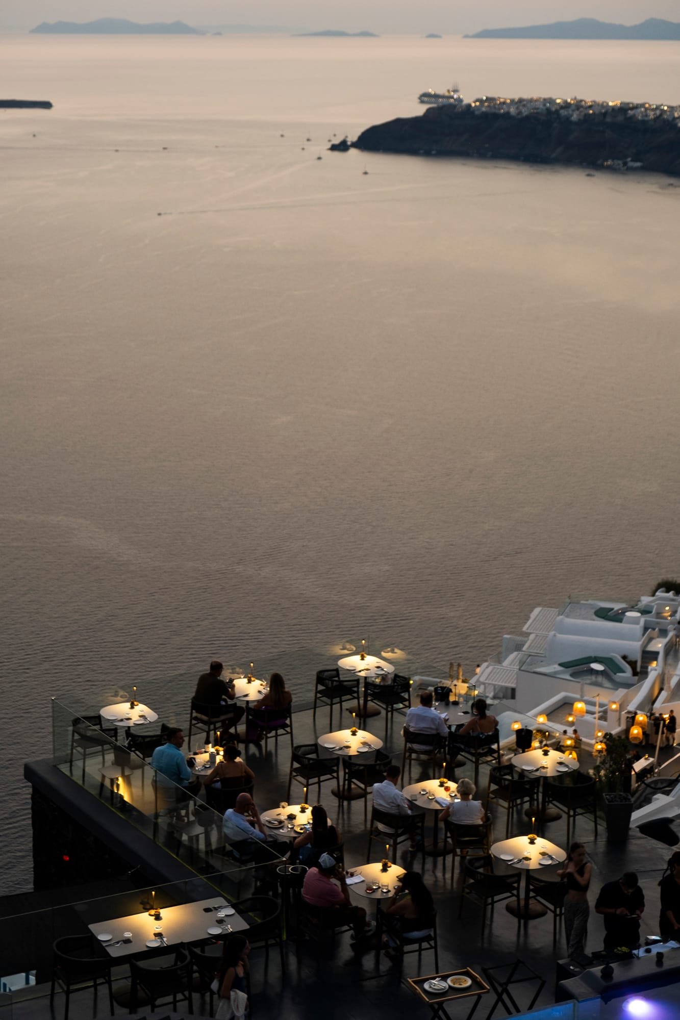 Mavro Restaurant, Imerovigli, Santorini — terrace tables lit at dusk above the caldera