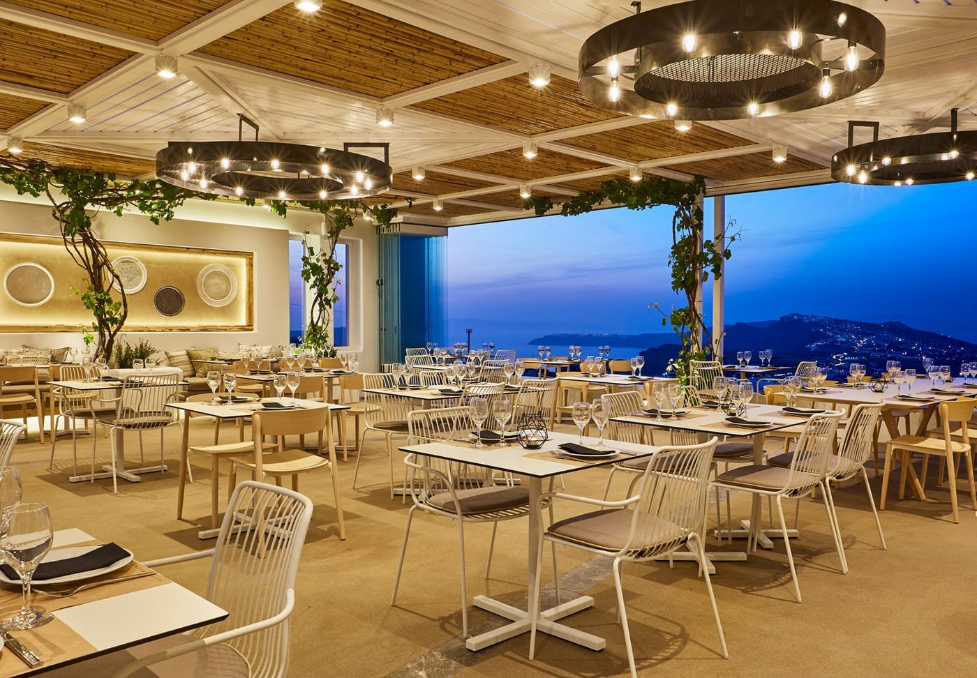 Pyrgos Restaurant, Pyrgos, Santorini — dining terrace lit at dusk with the caldera behind
