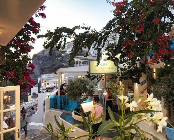 Volcano Blue Seafood Restaurant, Fira, Santorini — restaurant entrance and terrace under bougainvillea
