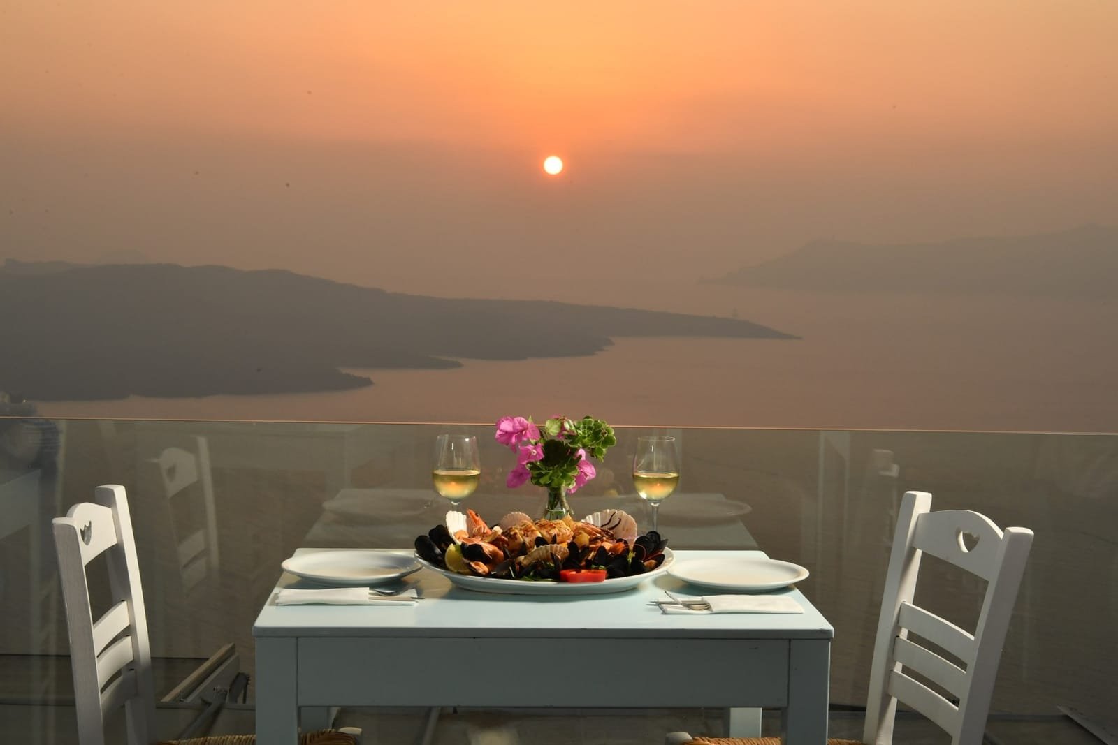 Volcano Blue Seafood Restaurant, Fira, Santorini — seafood platter at a caldera-view table at sunset